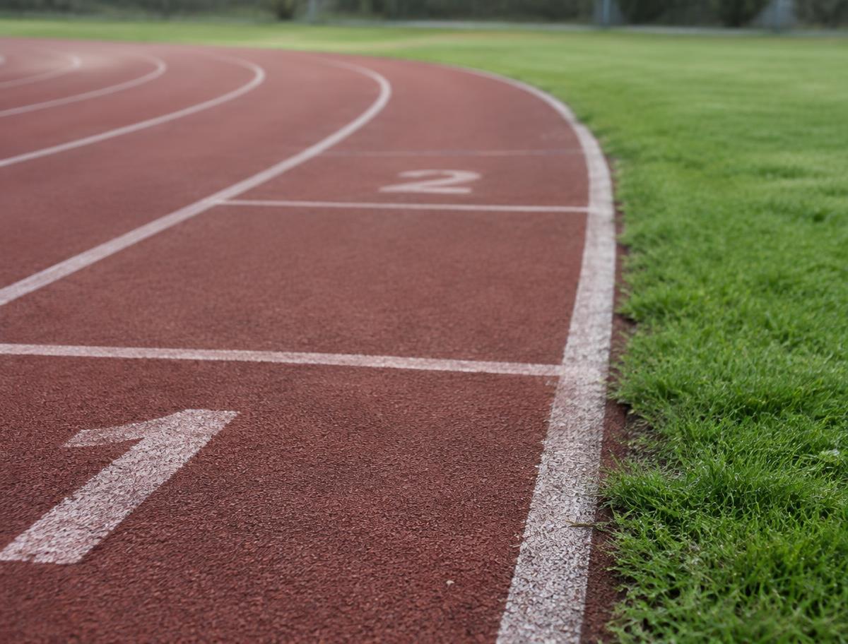 Running track lane markings beside grass, used for structured running sessions